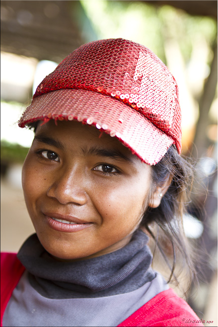 Portrait: Beautiful young Khmer woman in a red sequinned cap.