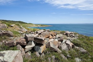 Pile of quarried granite in front of a blue cove.