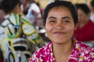 Portrait: Smiling Khmer woman in a bright pink shirt.