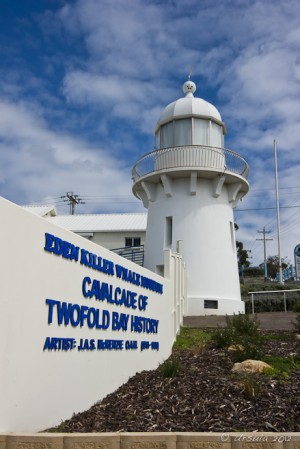 White wall: "Eden Killer Whale Museum..." and small white lighthouse.