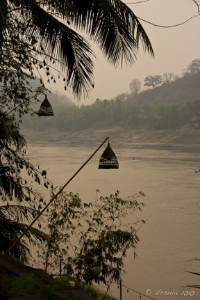 Evening light on the muddy Mekong River, Bamboo lamps in the foreground