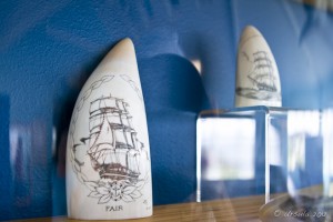 Two pieces of whale tooth, decorated with etched sailing ships.