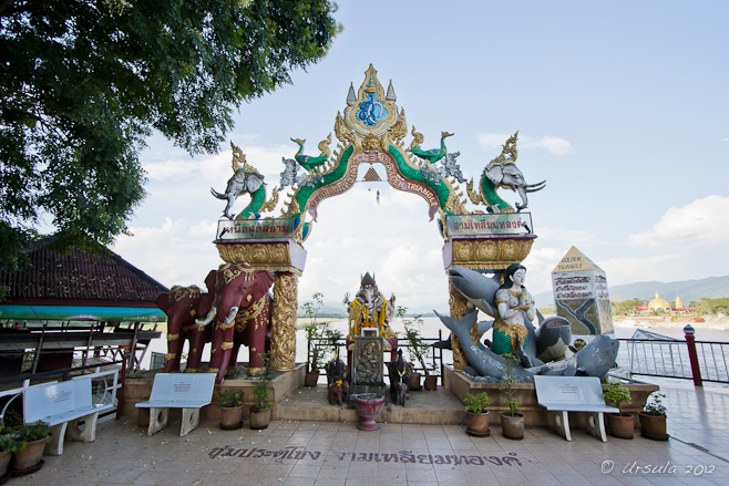 Brightly coloured, ornate archway, decorated with elephants and mermaids.