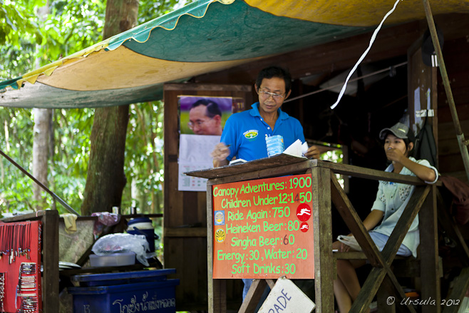 Thai man and young woman at a hut selling drinks, etc, in the rain forest.