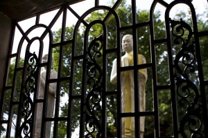 Buddhist statues outside a grilled window.
