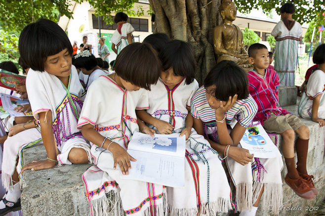 Karen Thai students grouped around a book.