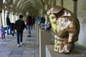Gold sculpture of a male torso in the arched cloisters of Salisbury Cathedral