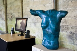 Sculpture of a female torso; LED screen in the background.