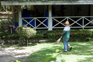 Thai gardener in straw hat and long sleeves