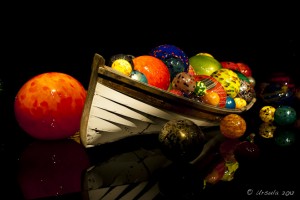 Wooden boat filled with colourful glass balls.