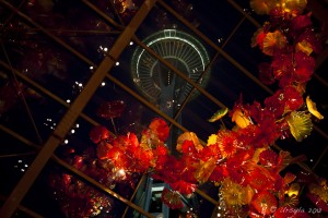 Seattle Space Needle framed by Chihuly glass flowers at night.