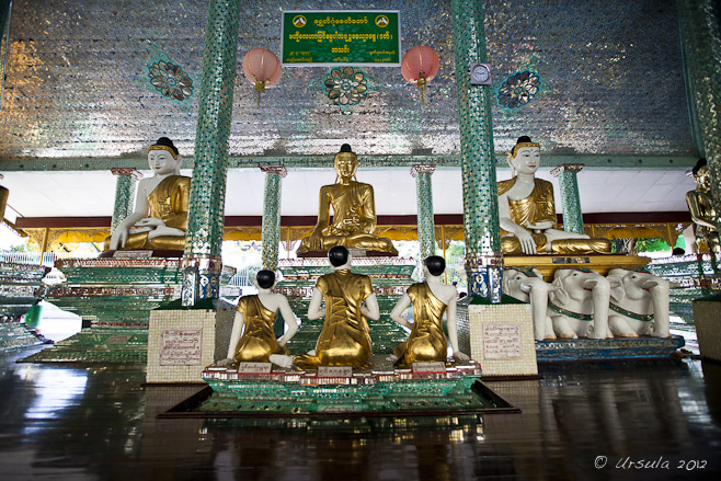 Large and small seated Burmese Buddhas in a lavishly tiled hall, Shwedagon.