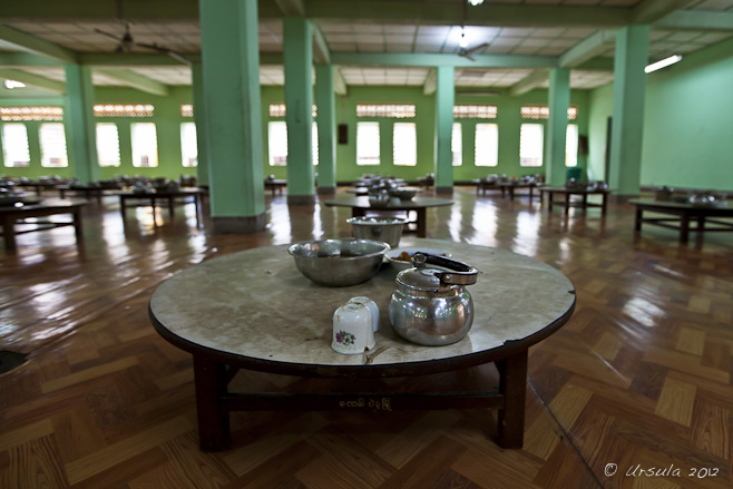 Low round table with tin tea pot and food bowls, Kyahkatwine Monastery, Bago, Myanmar