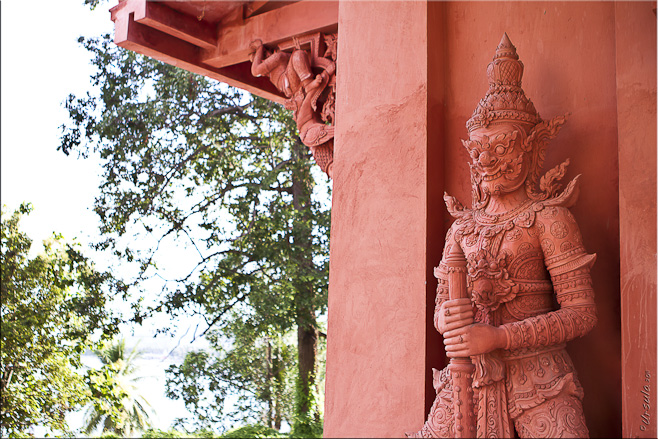 Thai giant guardian in red clay at a temple front; Bay of Thailand in the background.