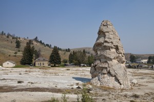 View of Liberty Cap, a dormant hot spring cone against the hills of Yellowstone NP.