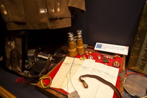 Museum display: papers, binoculars camera and clothing and medals from early 1900's Canada. Stave Falls Powerhouse.