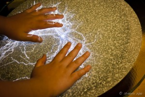 Child's hands on a static electricity display. Stave Falls Powerhouse