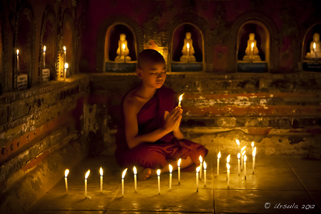 Burmese Novice monk holding a candle in prayer, Shwe Yan Pyay Monastery, Nyaung Shwe, Myanmar