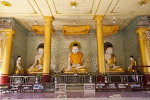 Three seated burmese buddhas draped in gold robes, Shwemawdaw Temple