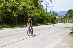 Female cyclist on a topical highway in white heat. Koh Samui Triathlon, 2012