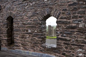 A Pembroke Castle tower seen through a wind in another tower.