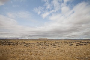 Wide-angle landscape: Eastern Wyoming's prairies under a blue sky with scattered clouds.