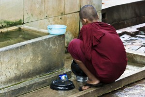 Young monk at a square water trough, washing dishes, Mahagandayon Monastery