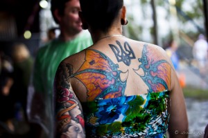 A woman's back, with a beautiful, colourful winged tattoo.