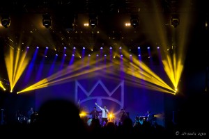 A distant stage, dark blue with yellow spot-lights; Felix Riebl singing. Bluesfest, 2013
