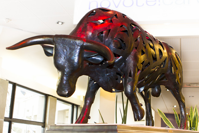 Modernistic sculpture of a bull under red and yellow light ~ Lucien Blanc 