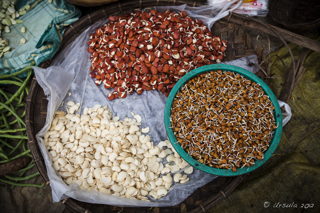 Three baskets of legumes in a Burmese morning vegetable market, Mandalay.