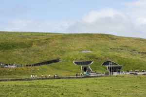 Landscape: Information Centre at the Cliffs of Moher; a green hillside with only windows and doors visible.