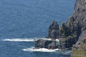 Seascape: rugged granite cliffs with a tunnel through, Cliffs of Moher, Co Clare, Ireland.