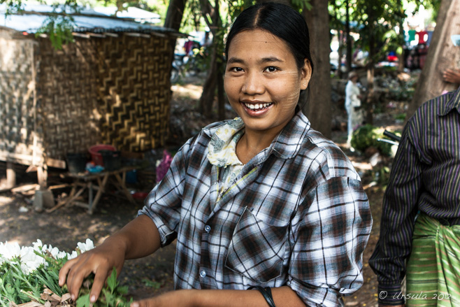 Portrait: Smiling Burmese woman in a black and white checkers shirt,  Pyin Oo Lwin Flower Market, Myanmar.