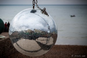 Brighton waterfront buildings reflected in a large disco ball, Brighton Beach, UK