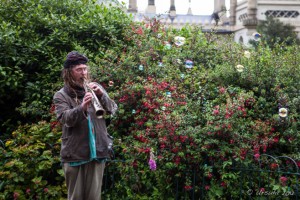 A Clarinetist in dreadlocks and tattered clothes plays while bubbles float on the air, Royal Pavilion, Brighton, UK