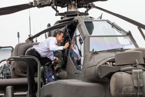 Man in a white dress shirt looking into a Boeing AH-64 Apache Helicopter, Singapore Airshow 2014