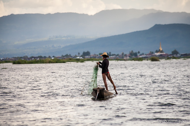 A leg-rowing fisherman ready to cast his net, Inle Lake, Myanmar