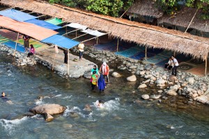 Beach huts on the rocky shore of the Bahorok River, Bukit Lawang, Indonesia