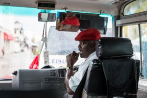 Bahamian man with a microphone, driving a mini bus, Nassau.