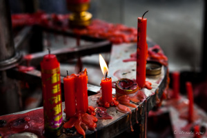 Red candles burning on a metal wheel, Longshan Temple, Quanzhou China