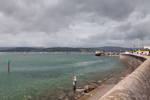 Fisherman on the rocks at the Exmouth Seawall, UK