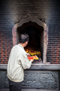 Chinese man Burning Joss Paper, Ritual furnace Guandi Temple, Quanzhou China