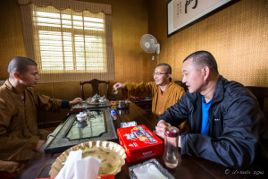 Two Chinese Buddhist monks and a lay man at a table, Jinjiang, China