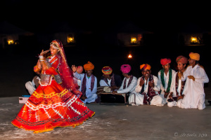 A Kalbelia Dancer in a red gypsy dress and musicians, Manvar Desert Camp, Dechu, India