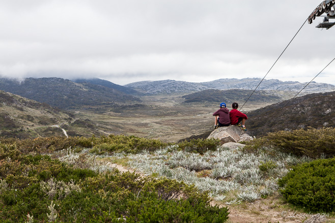 Two young men on a rock overlooking Charlotte Pass, Kosciuszko National Park, AU