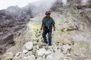 A Sumatran guide on sulphure coated rocks, Mount Sibayak, North Sumatra, Indonesia