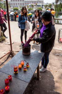 A woman lighting incense, Nan Putuo Temple, Xiamen, Fujian Province, China