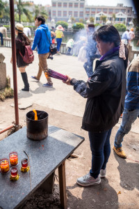 A woman lighting incense, Nan Putuo Temple, Xiamen, Fujian Province, China