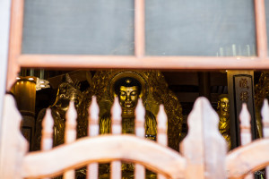 golden Buddha and Bodhisattva images behind a wooden rail, Nan Putuo Temple, Xiamen, Fujian Province, China